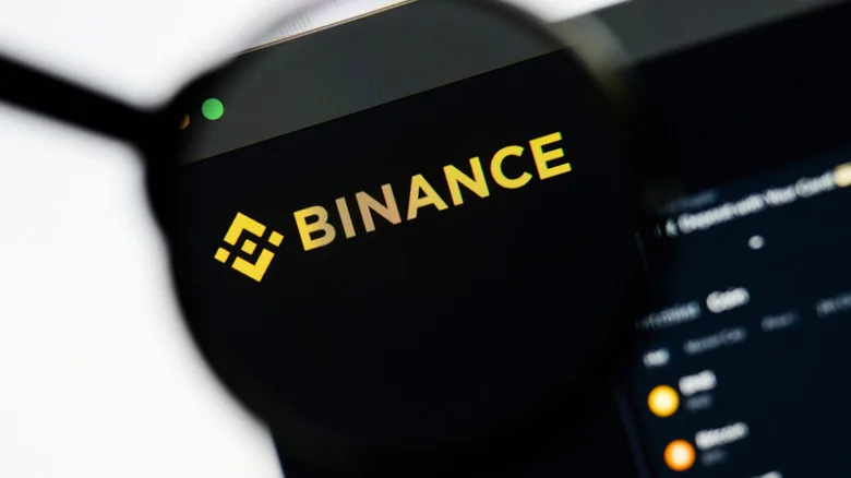 Binance logosu bilgisayar ekranındaki bir büyüteç altında gösteriliyor
